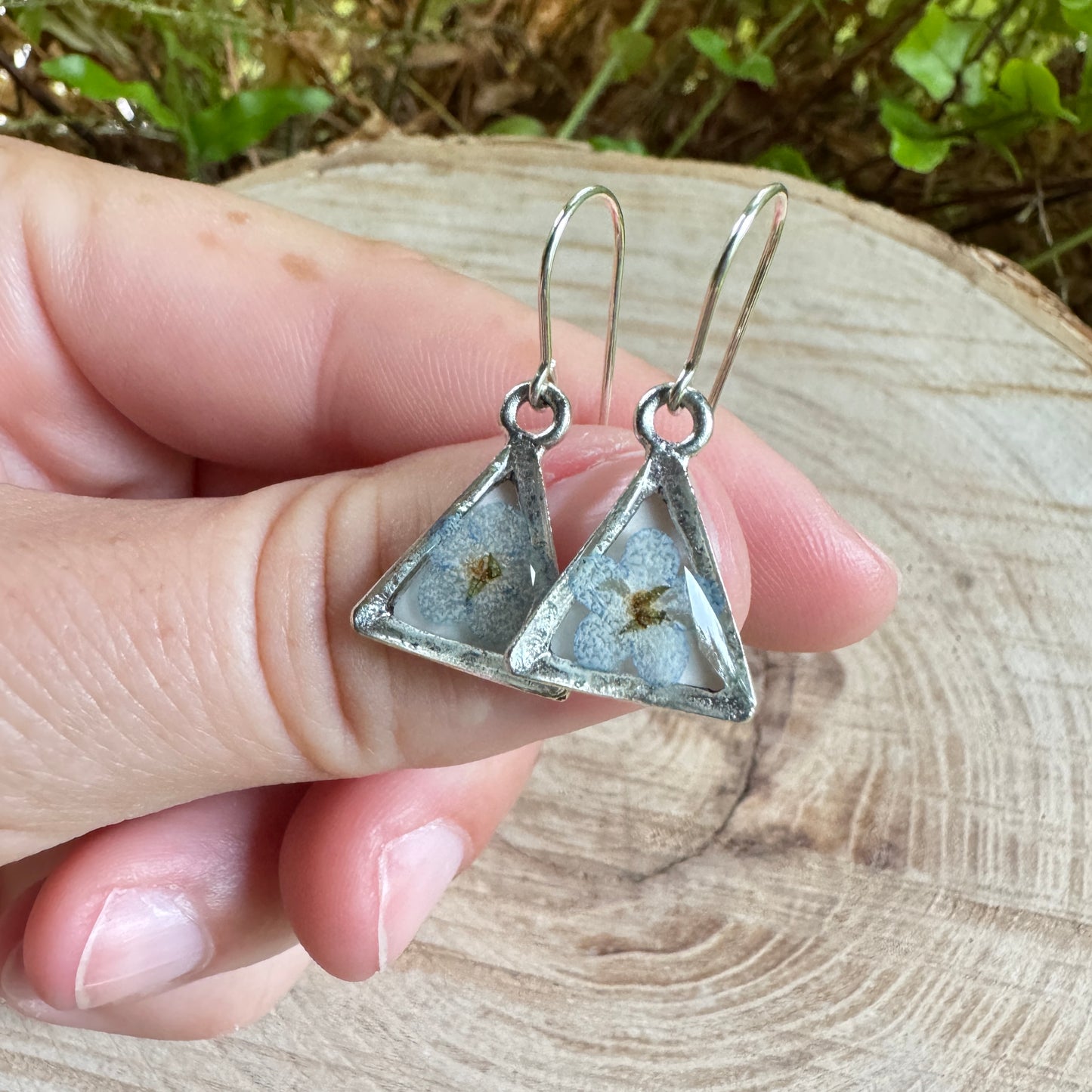 Earrings with real forget-me-not flowers preserved in resin and set in silver bezels