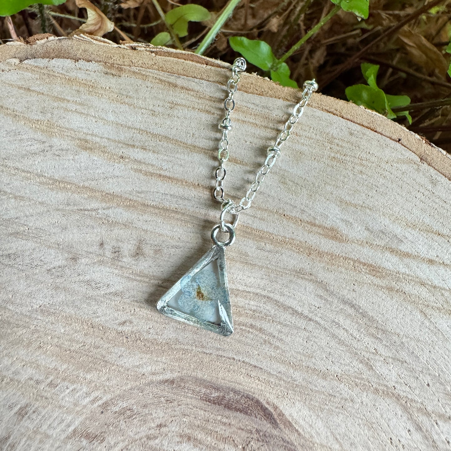 Forget-me-not flower preserved in resin and set in a silver pendant necklace