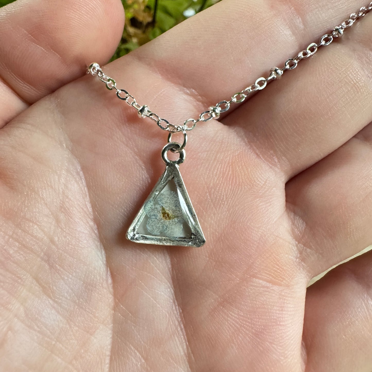 Forget-me-not flower preserved in resin and set in a silver pendant necklace