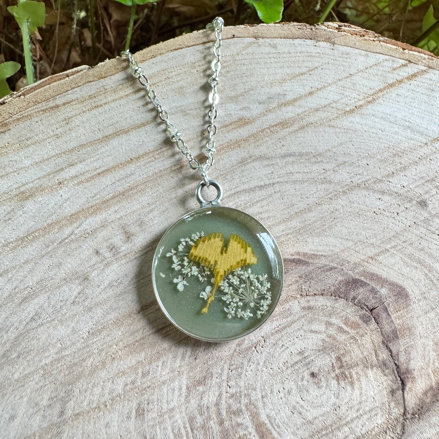 Necklace with real Queen Anne’s Lace and ginkgo leaf preserved in resin with silver bezel