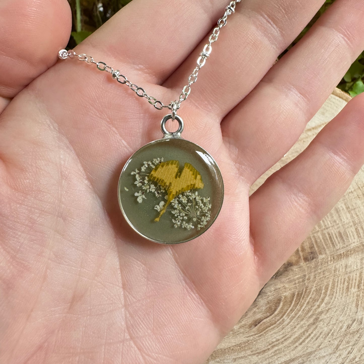 Necklace with real Queen Anne’s Lace and ginkgo leaf preserved in resin with silver bezel