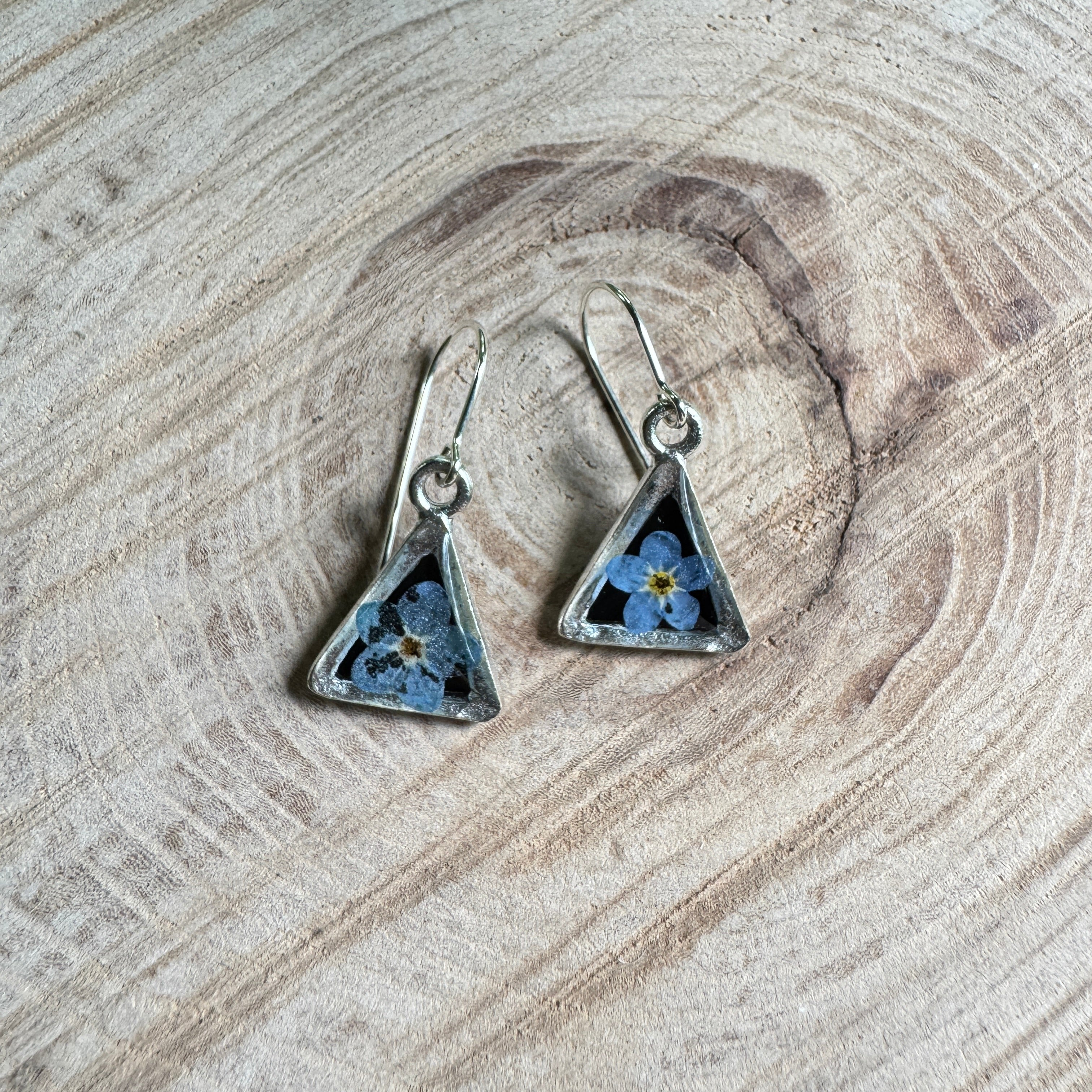 Earrings with real forget-me-not flowers preserved in resin and set in silver bezels