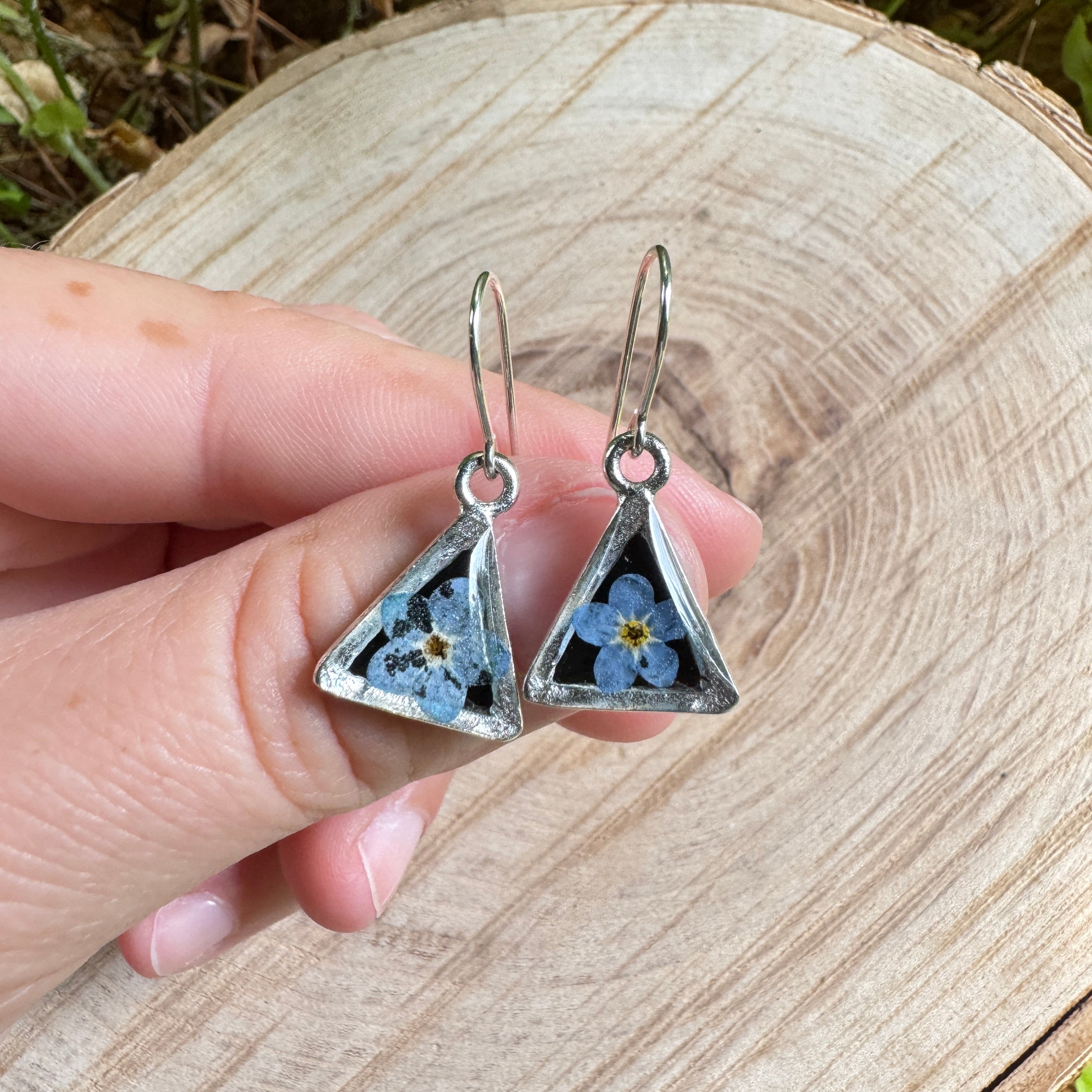 Earrings with real forget-me-not flowers preserved in resin and set in silver bezels