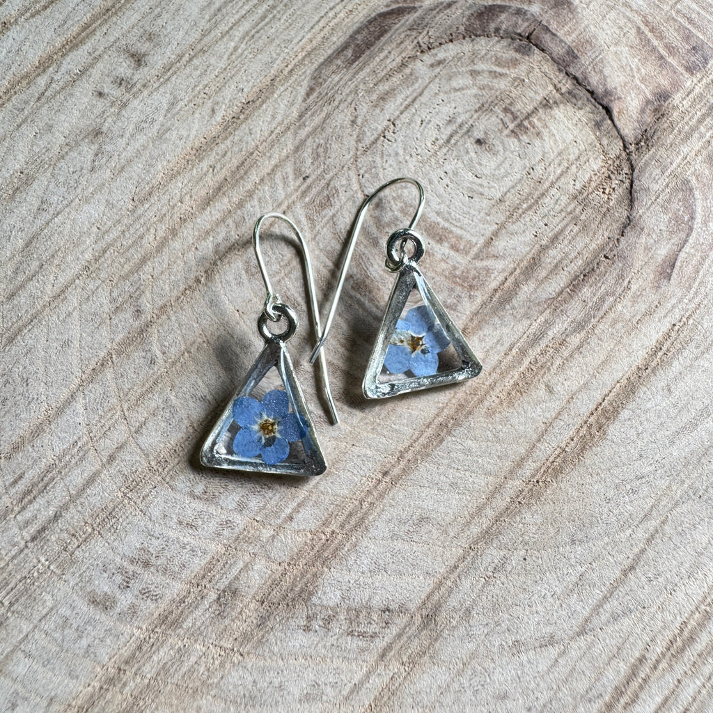 Earrings with real forget-me-not flowers preserved in resin and set in silver bezels