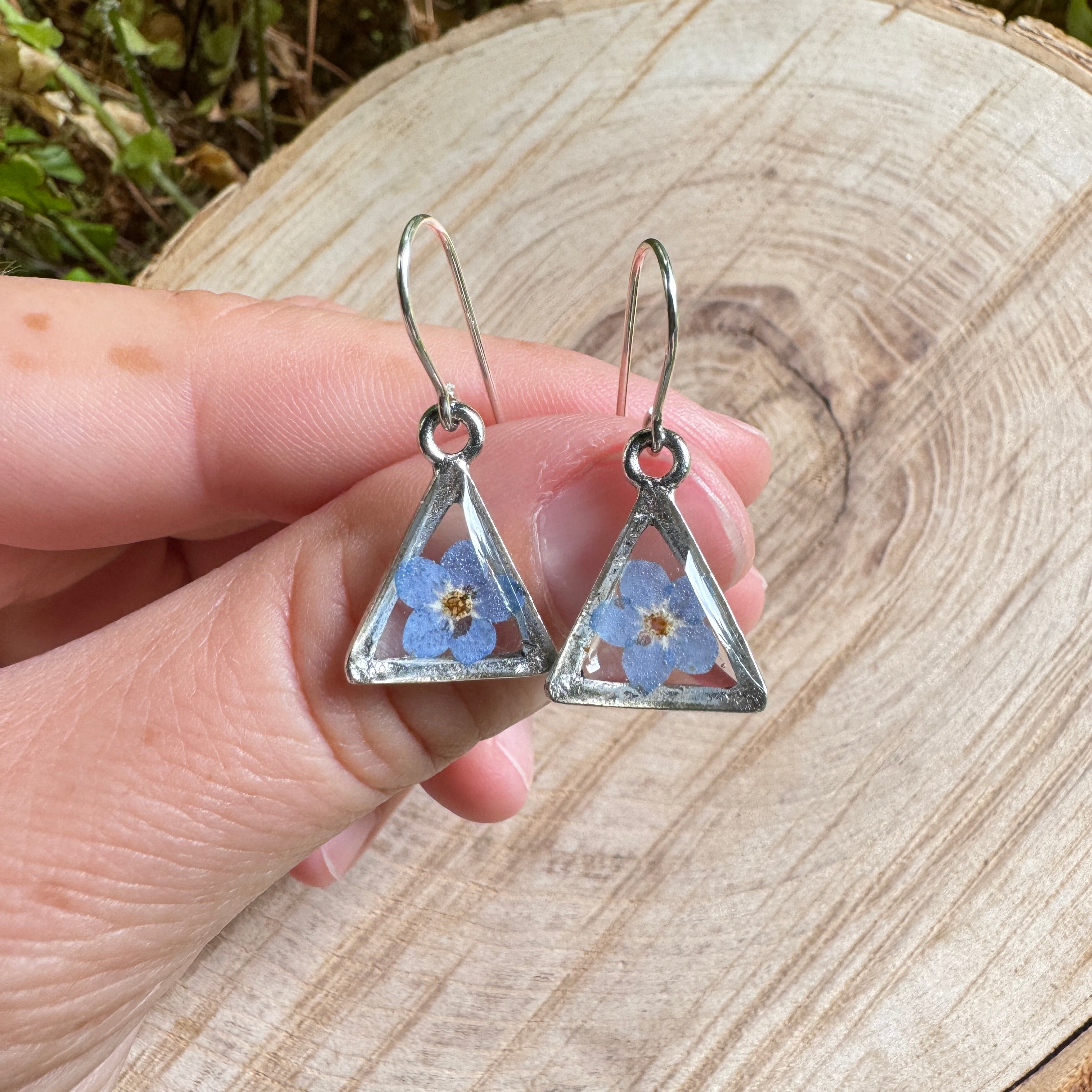 Earrings with real forget-me-not flowers preserved in resin and set in silver bezels