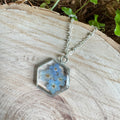 Forget-me-not flower preserved in resin and set in a silver pendant necklace