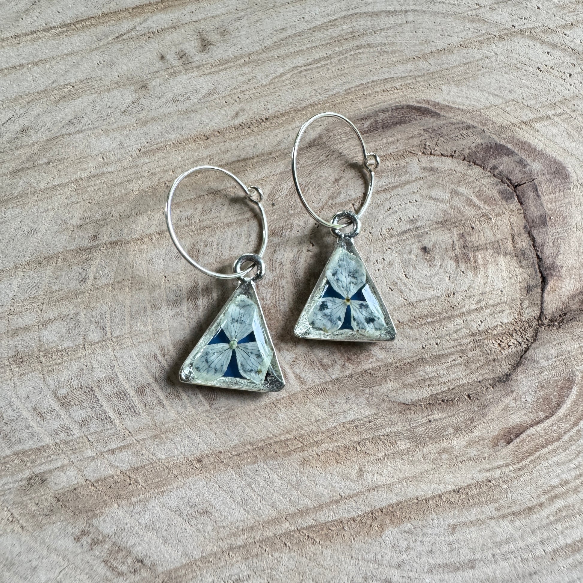 Earrings with real hydrangea petals preserved in resin and silver bezels