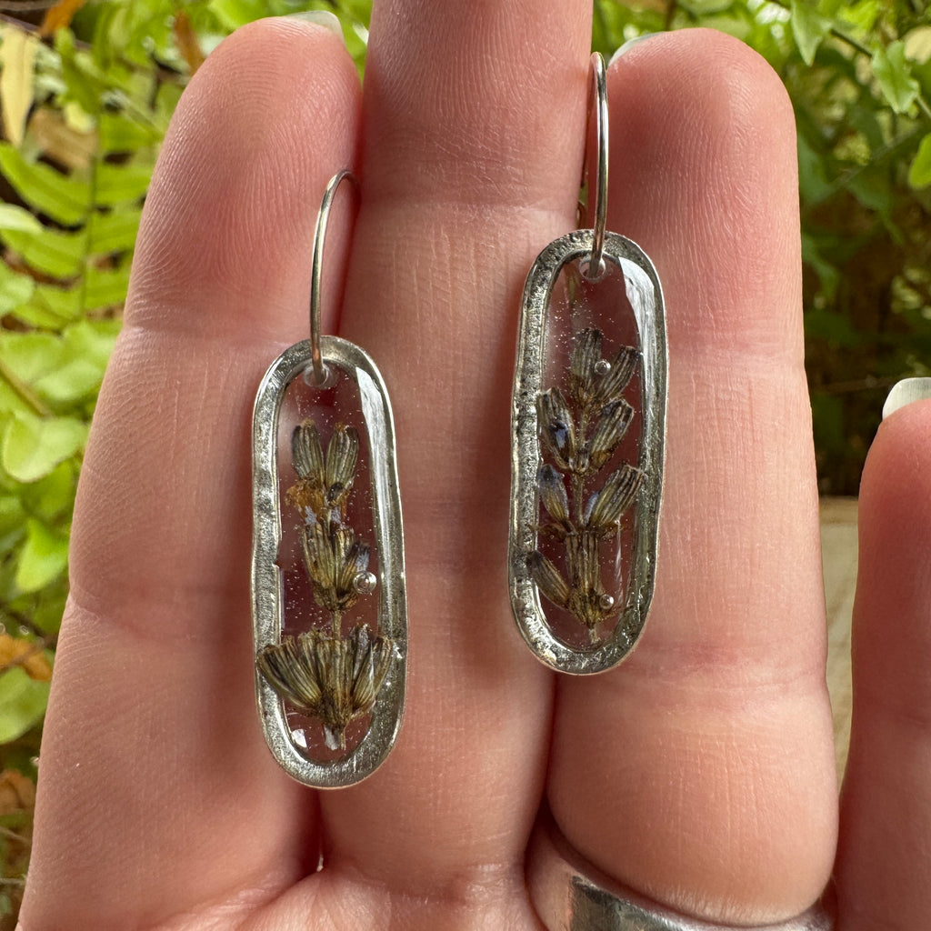 Handmade real lavender oval earrings featuring preserved lavender in resin with sterling silver ear wires.
