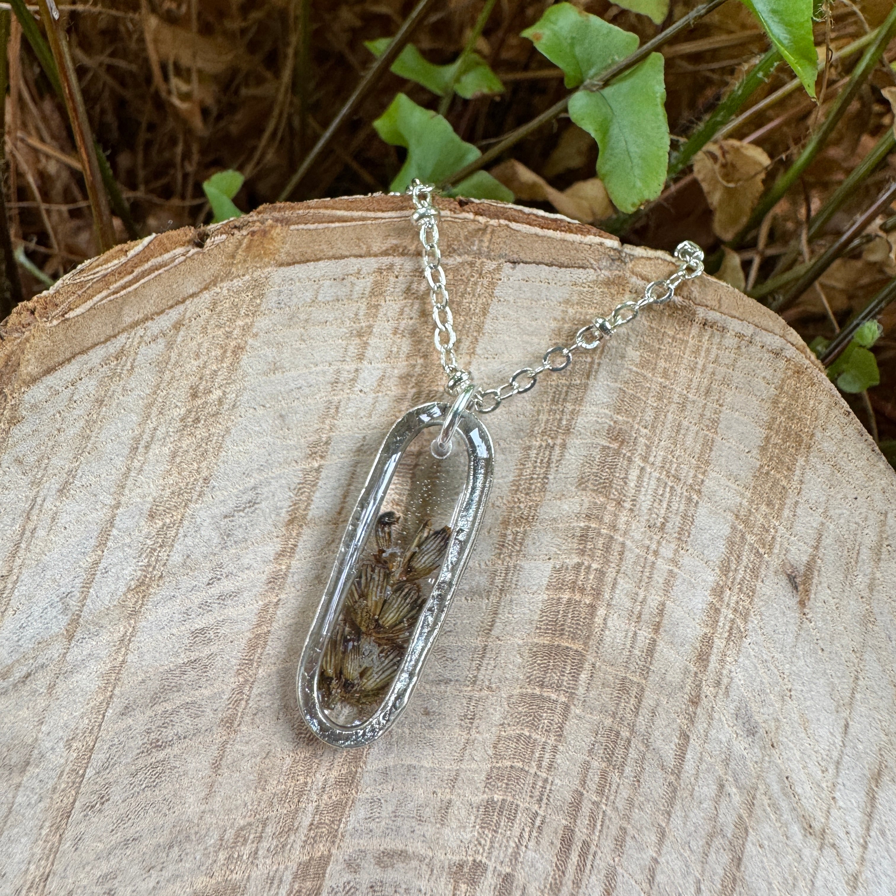 Handmade real lavender oval necklace featuring preserved lavender in resin with First Light clear background, available in sterling silver.