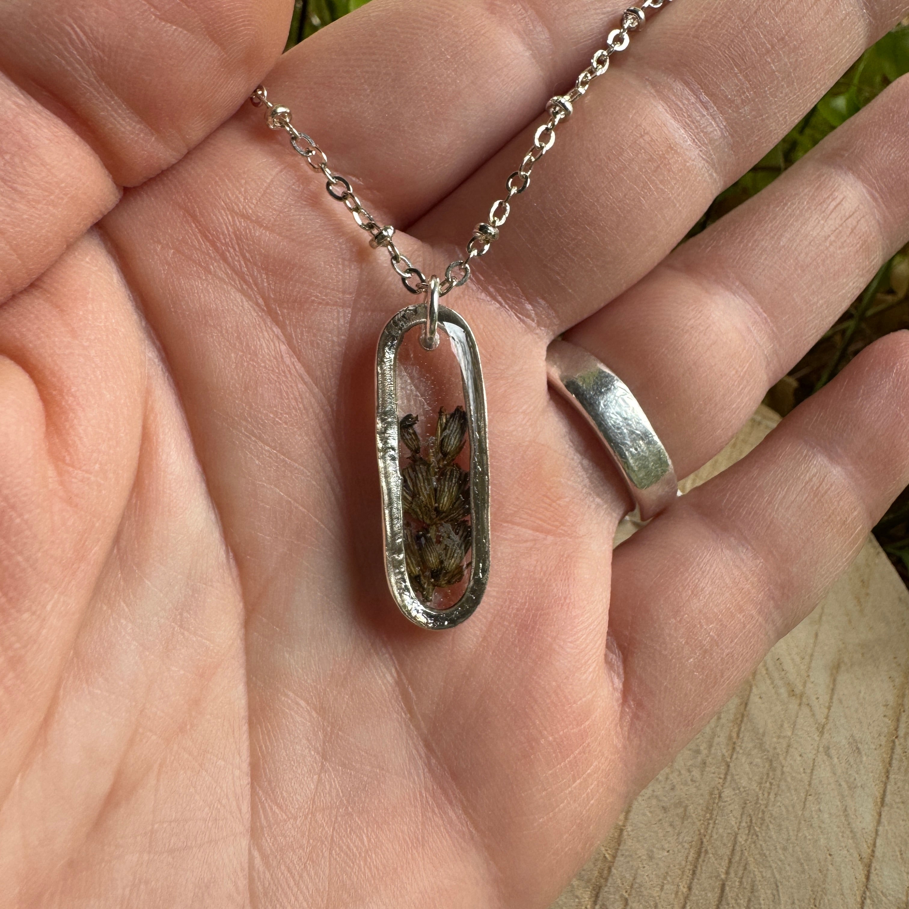Handmade real lavender oval necklace featuring preserved lavender in resin with First Light clear background, available in sterling silver.