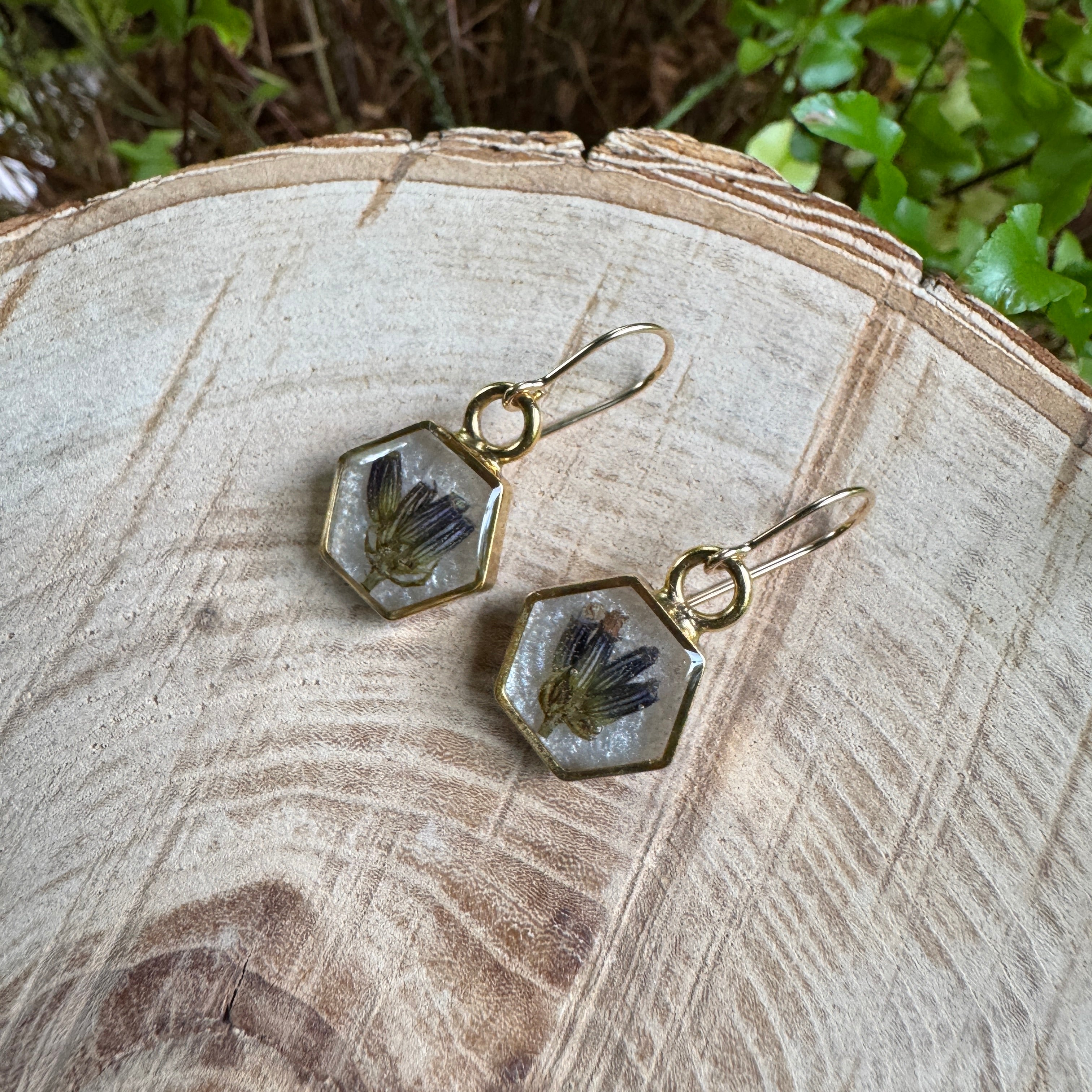 One-of-a-kind handmade gold filled hexagon earrings featuring real preserved lavender in resin with a Morning Mist white background.